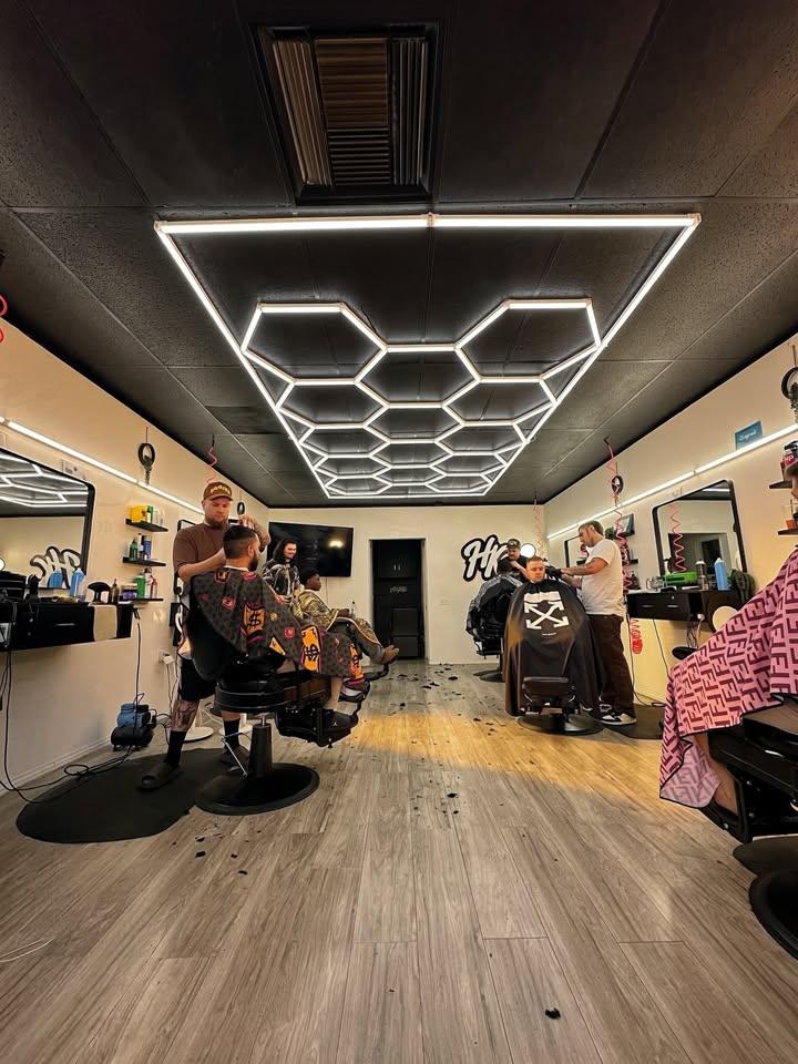 Barber grooming a client at Hair Kulture Studio